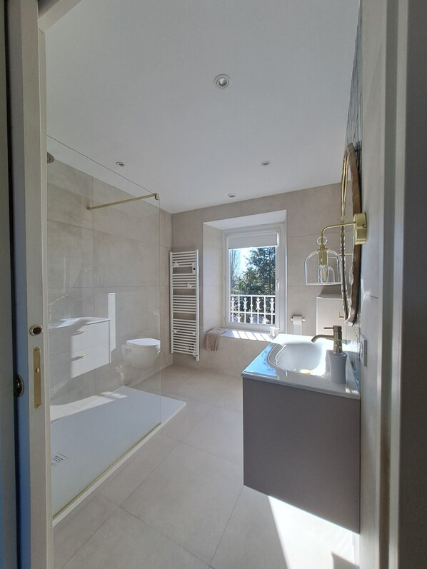 A modern bathroom with a bathtub, toilet, and sink. - Chambre d'hôtes le lac (Cherrueix)