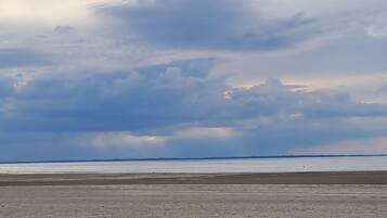 Une plage avec une vaste étendue de sable et un ciel nuageux.