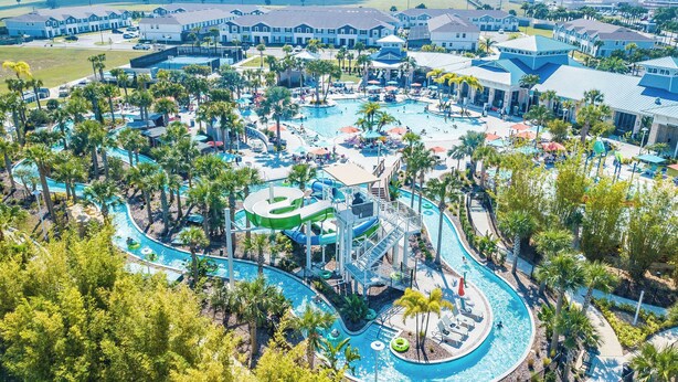 Un complejo turístico con una amplia piscina central, varias toboganes acuáticos y diversas zonas de estar al aire libre.