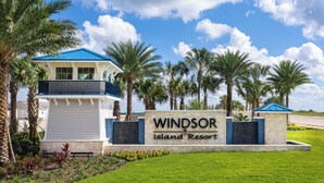 Señal para Windsor Island Resort, con un edificio moderno y palmeras.