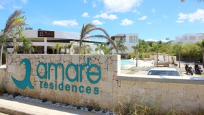 A stone wall with the text "Amarte Residences" and a sign indicating "150 Grados".