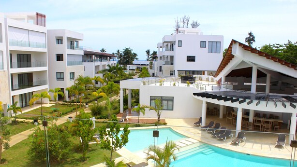A resort with a swimming pool, multiple balconies, and outdoor seating areas.