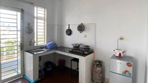 A compact kitchen with a gas stove, a sink, and a refrigerator. - Combretrata (Phnom Penh)