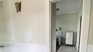 A spacious room with a tiled floor and a doorway leading to a kitchen area. - Combretrata (Phnom Penh)
