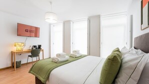 A hotel room with a bed, a desk, a chair, a television, and a window. - GuestReady - Invicta Porto GuestHouse - Room 003 (Porto)