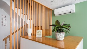 A wooden staircase with a white wall and an air conditioning unit above. - GuestReady - Invicta Porto GuestHouse - Room 003 (Porto)