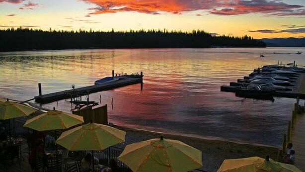 A lakeside view with a dock and umbrellas. - Lookout Lodge at Cavanaugh's (Coolin)