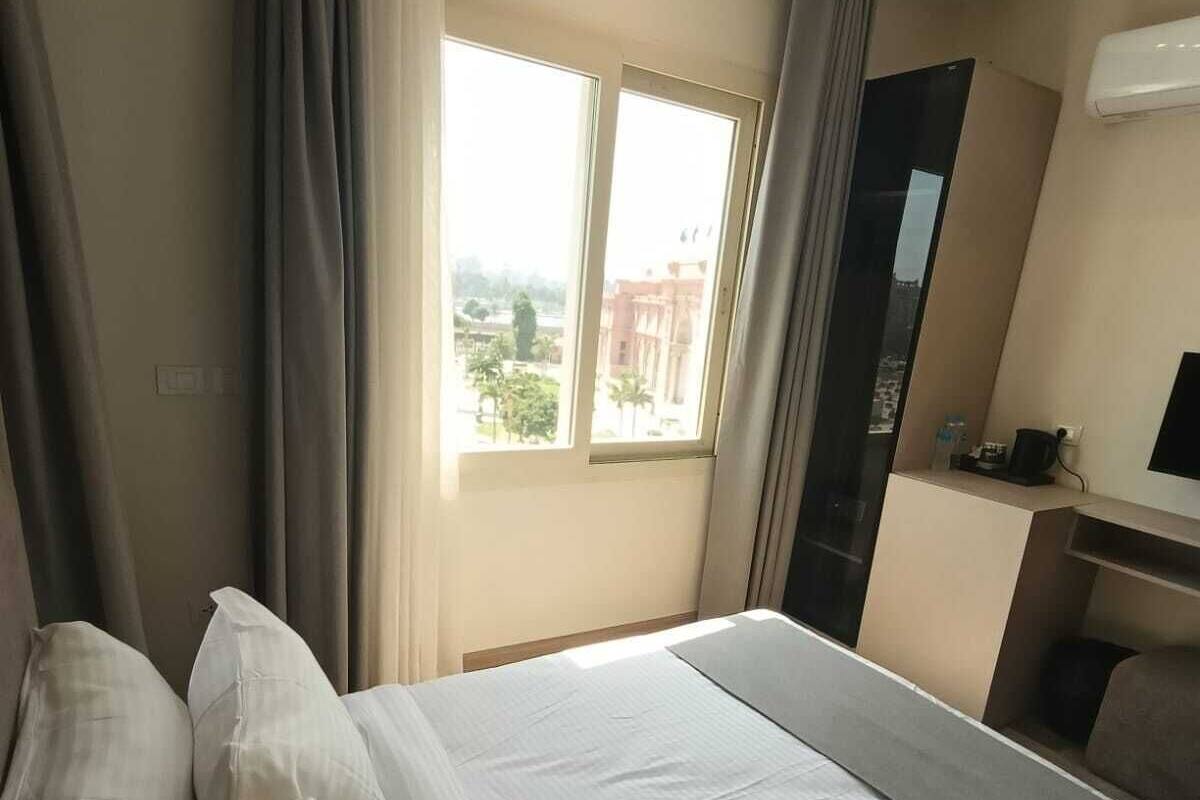 Una camera d'albergo con un letto grande, una scrivania e una finestra con tende.