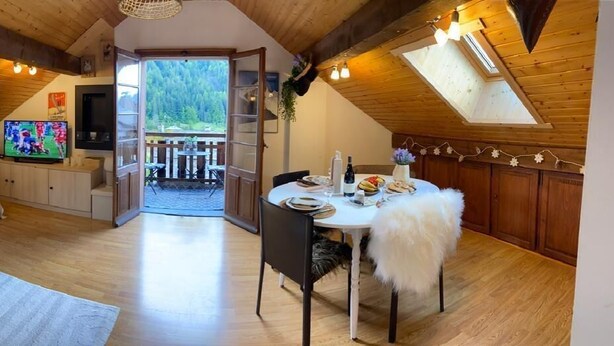 A cozy attic bedroom with a sofa, a TV, and a dining area with a table and chairs. - 50m from resort center, 3rd floor, balcony, parking, tv, ski locker, 25m², Le Grand Bornand (Le Grand-Bornand)