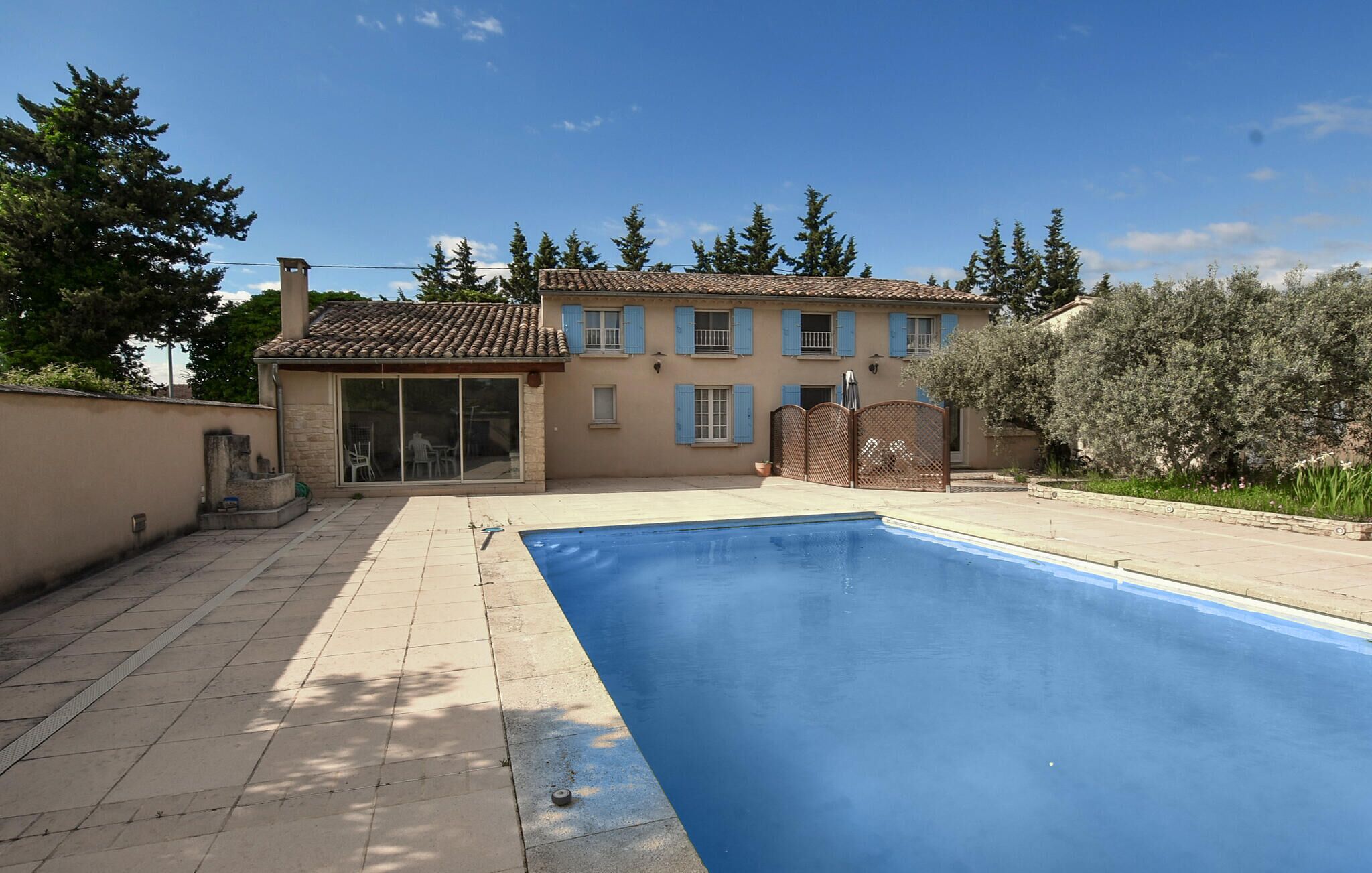 A house with a swimming pool, a patio, and a garden.
