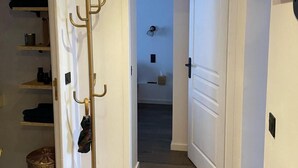 A hallway with a coat rack, a basket, and a door leading to another room. - 100m from resort center, 3rd floor, balcony, tv, ski locker, 35m², Le Grand Bornand (Le Grand-Bornand)