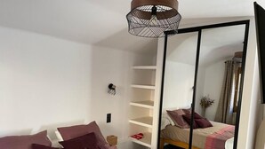 A bedroom with a bed, a wardrobe, and a mirror. - 100m from resort center, 3rd floor, balcony, tv, ski locker, 35m², Le Grand Bornand (Le Grand-Bornand)