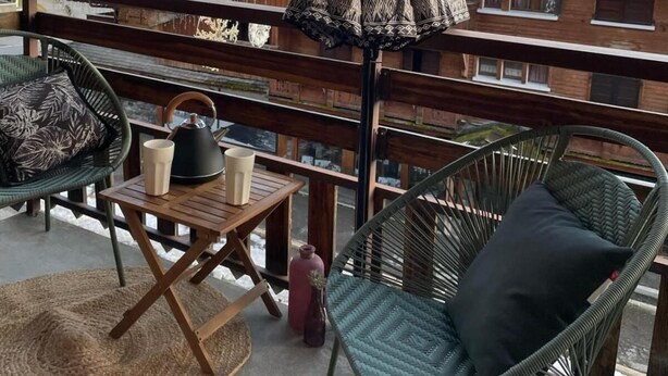 A balcony with wicker chairs, a table with two cups, and a view of snow-covered mountains. - 100m from resort center, 3rd floor, balcony, tv, ski locker, 35m², Le Grand Bornand (Le Grand-Bornand)