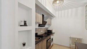 Een moderne keuken met houten kastjes, een inbouwoven en een spoelbak.