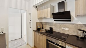 Een moderne keuken met een inbouwoven, een kookplaat en een spoelbak.