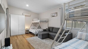 Cozy room with a bunk bed setup, comfortable sofa, and ample storage.