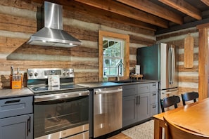Una cocina moderna con electrodomésticos de acero inoxidable, paredes de madera y una ventana que proporciona luz natural.
