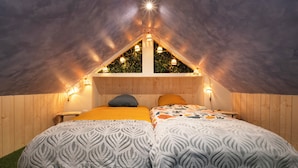 A cozy attic bedroom with two beds, a sloped ceiling, and string lights. - La Cabane - deux chambres et grande terrasse  ⭐️⭐️⭐️ (Metz)