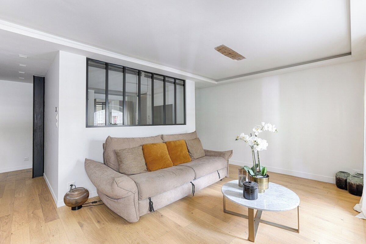 Een moderne woonkamer met een bank, een salontafel en een raam.