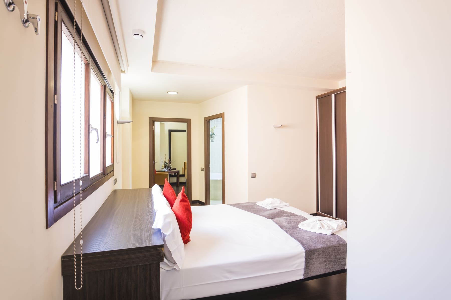 Una habitación de hotel con cama, escritorio y ventana.