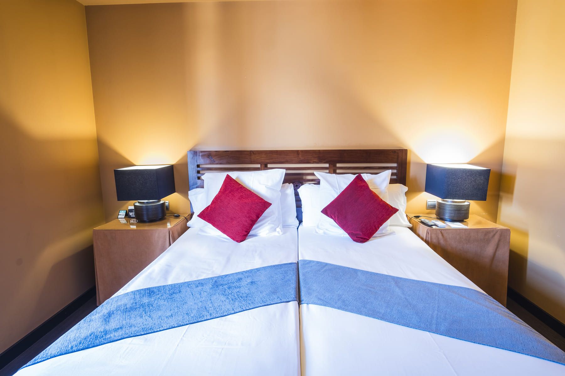 A hotel room with a large bed, two nightstands, and two lamps.