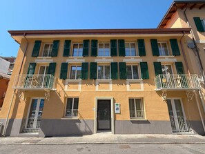 Un immeuble à plusieurs étages doté de balcons, d’une porte et d’une enseigne indiquant qu’il s’agit d’un commerce.