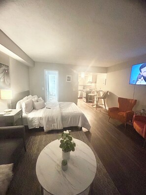 Een hotelkamer met een bed, een bureau, een stoel, een televisie en een salontafel.