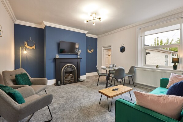 A living room with a fireplace, a television, and a dining area. - Arbeia in South Shields (South Shields)