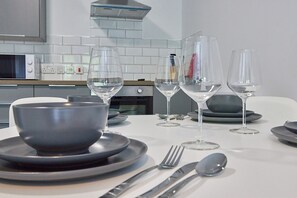 A dining table set with plates, bowls, cutlery, and wine glasses. - Low Lights in North Shields (North Shields)