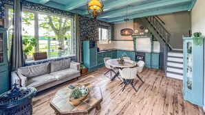 A cozy living room with a sofa, a coffee table, and a dining area with chairs. - Cozy home in Harich with WiFi (Harich)