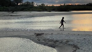A beach scene with a person walking along the shore. - Tulua House on Galu Beach: Private Villa @ Tamani (Diani)