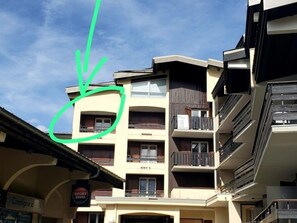Un edificio de varios pisos con balcones, un letrero que dice 'Consigne 2000', y un cielo despejado.
