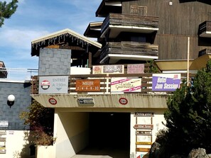 A hotel with multiple signs advertising various services and amenities, including a sports center, a gourmet restaurant, and a jam session event.