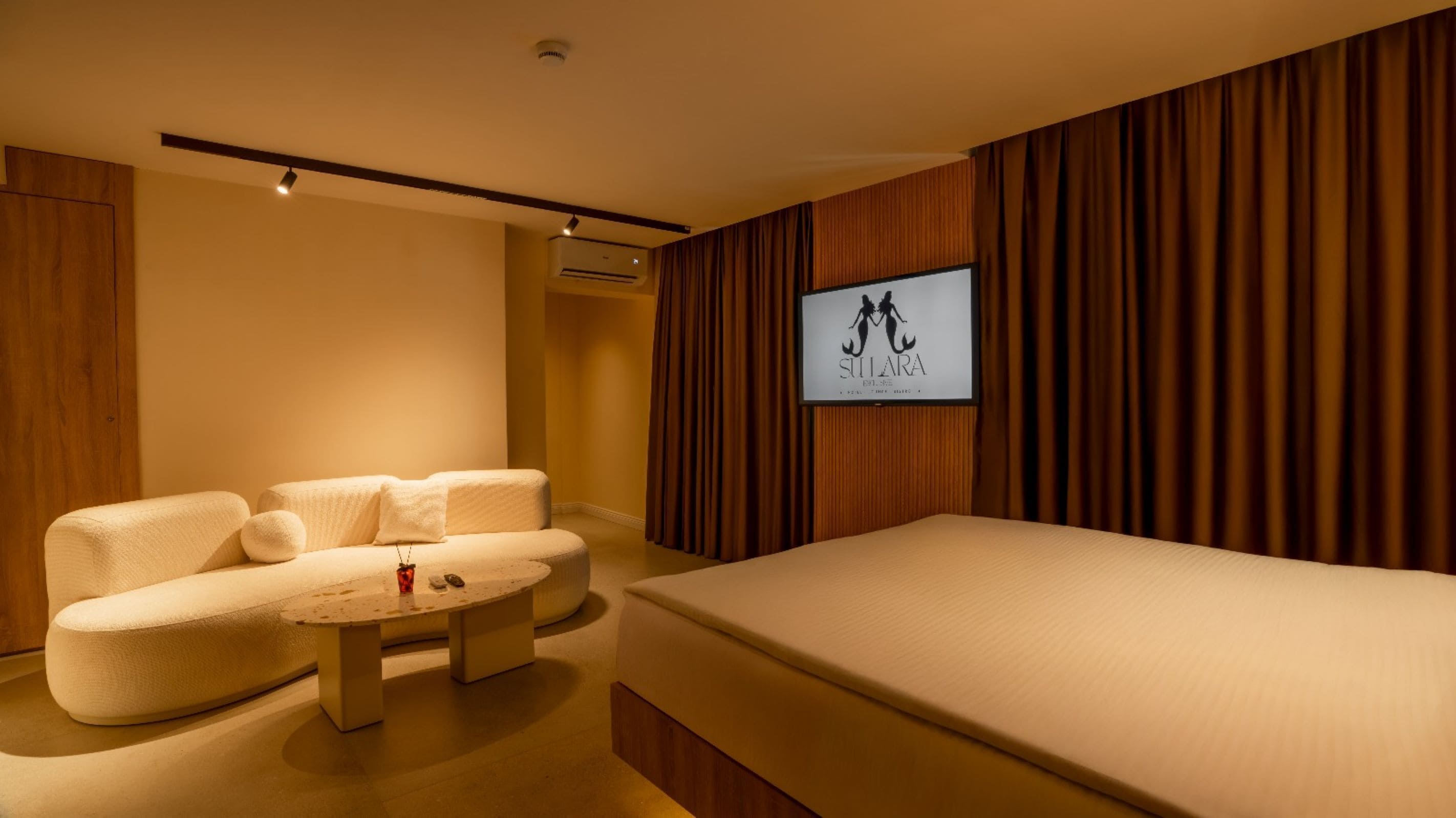 A modern bedroom with a sofa, a round coffee table, and a bed.