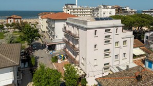 Un immeuble à plusieurs étages doté de balcons, d’un espace de stationnement et offrant une vue sur la mer.