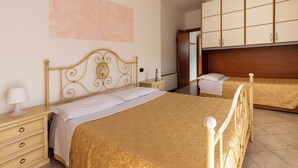 Une chambre à coucher avec un lit double, une table de chevet, une commode et une armoire.