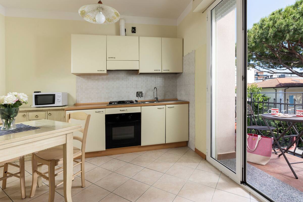 Une cuisine compacte comprenant un coin repas, un four à micro-ondes, une cuisinière et un évier.