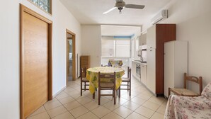 Un comedor con una mesa, sillas y un ventilador de techo.
