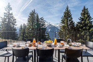 A dining table set outdoors with a mountain view, surrounded by chairs. - Wifi, view valley, terrace, tv, ski locker, 100m², La Rosière (La Rosière Montvalezan)
