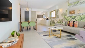 A modern living room with a sofa, a coffee table, and a dining area with chairs. - 217 Le Jungle in Cannes (Cannes)