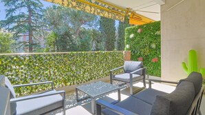 A balcony with a glass table, two grey sofas, and a green cactus. - 217 Le Jungle in Cannes (Cannes)