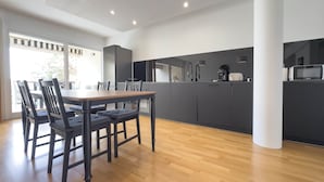 A modern kitchen with dark cabinets, a wooden dining table, and chairs. - 213 Le Montfleury in Cannes (Cannes)