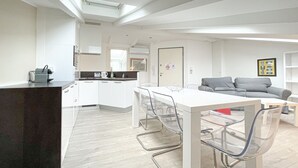 A modern kitchen with white cabinets, a black countertop, and a skylight. - 210 - Tony Allard 4A (Cannes)