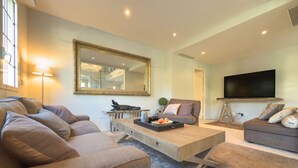 Ein modernes Wohnzimmer mit Sofa, Couchtisch und Fernseher.