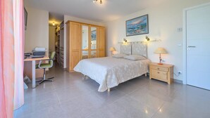 A bedroom with a bed, a desk with a chair, a wardrobe, and a bedside table with lamps. - Le Rooftop in Cannes (Cannes)