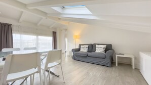 A modern living room with a grey sofa, white chairs, a dining table, and a skylight. - 4B Tony Allard in Cannes (Cannes)