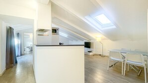 A modern kitchen with a central island, a dining area with chairs, and a TV mounted on the wall. - 4B Tony Allard in Cannes (Cannes)