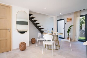 A modern dining area with a round table, white chairs, and a staircase leading to another level. - 320 Le Loft Palatin in Cannes (Cannes)