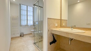 Un bagno moderno con cabina doccia in vetro, un water e un lavabo con specchio.