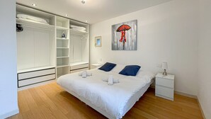 Una camera da letto con un letto grande, una cabina armadio e un quadro appeso al muro.